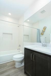 La salle de bains est pourvue d'un lavabo, de toilettes et d'une baignoire. dans l'établissement Modern & Furnished Home near Downtown & Fort Sam, à San Antonio