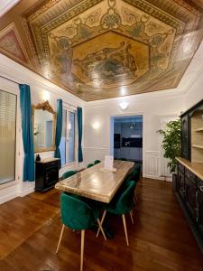 une salle à manger avec une table et des chaises vertes dans l'établissement Appartement de luxe avec fresque, à Fontainebleau