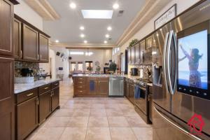 a large kitchen with wooden cabinets and a tv at Desert Hills - An Irvie Home in Albuquerque