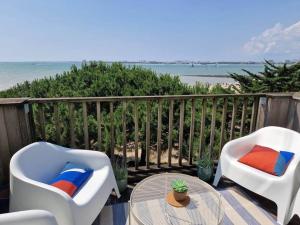 - deux chaises et une table sur un balcon avec vue sur la plage dans l'établissement Appartement aux Minimes Magnifique Vue Mer au pied de la Plage 50m2-2ch., à La Rochelle