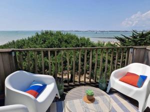 two chairs and a table on a balcony with the beach at Appartement aux Minimes Magnifique Vue Mer au pied de la Plage 50m2-2ch. in La Rochelle