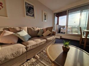 - un salon avec un canapé et une table dans l'établissement Appartement aux Minimes Magnifique Vue Mer au pied de la Plage 50m2-2ch., à La Rochelle