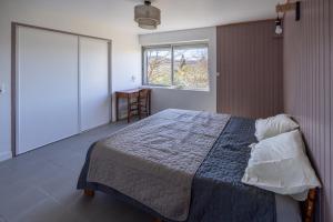 1 dormitorio con cama, ventana y mesa en Pamiers gare - 2 Appartements à louer ou Chambre parentale indépendante en Pamiers