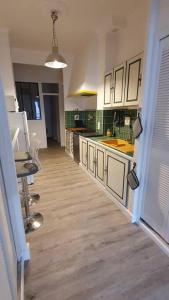 cocina con armarios blancos y suelo de madera en Appartement centre-historique 70 m2 en Fréjus