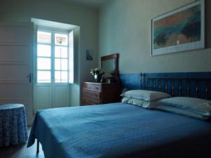 a bedroom with a blue bed with a dresser and a window at Mister G home in the heart of Turin in Turin