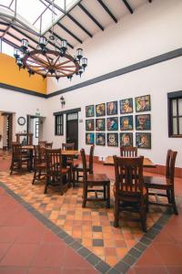 a dining room with tables and chairs and pictures on the wall at Hotel Boutique San Antonio in Cali