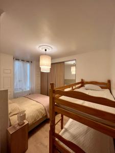 1 dormitorio con 2 camas y lámpara de araña en Appartement de luxe avec fresque, en Fontainebleau