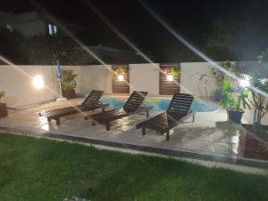 um grupo de cadeiras sentadas ao lado de uma piscina à noite em Casa de Praia Pinheira com Piscina para 8 pessoas em Palhoça