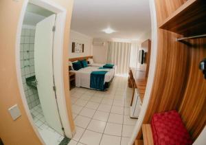 Habitación con vistas a un dormitorio con cama y espejo. en DiRoma Exclusive, en Caldas Novas