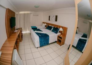 een hotelkamer met een bed en een televisie bij DiRoma Exclusive in Caldas Novas