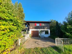 a house with a garage and a fence at Romantischer studio mit grosser Terrasse in Salavaux