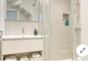 y baño blanco con lavabo y ducha. en CASA CASCO HISTÓRICO, en Sevilla