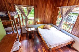 Cette petite chambre comprend un lit et deux lits superposés. dans l'établissement Pension Santa Elena, à Monteverde Costa Rica