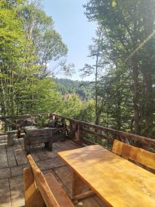una terraza de madera con bancos y vistas a las montañas. en Vikendica Čeperković #1 en Kopaonik