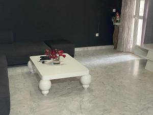 a living room with a white table with flowers on it at S2 ain zaghwen nord la marsa in La Marsa