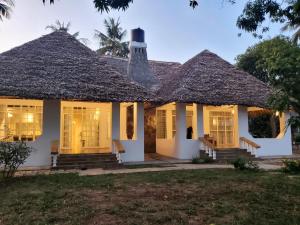 una casa con techo de paja en Mangos Villas - Lucia en Kilifi