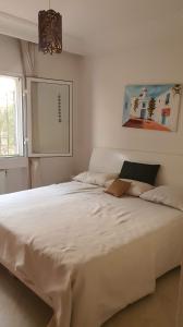 a large white bed in a room with a window at S2 ain zaghwen nord la marsa in La Marsa