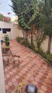 a patio with a table and a bench and a vacuum at عين زغوان الشمالية المرسي in La Marsa