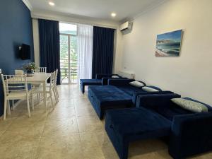 una sala de estar con 4 sofás azules y una mesa. en Blue Apartment en Gonio