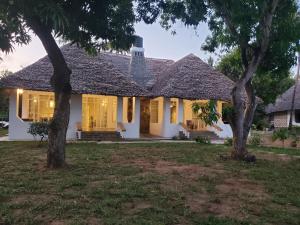 a white house with trees in the yard at Mangos Villas - Chiara in Kilifi