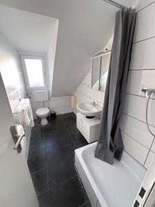 ein Badezimmer mit einer Badewanne, einem Waschbecken und einem WC in der Unterkunft Zentrale Wohnung für 4 mit Bett und Schlafcouch in Essen