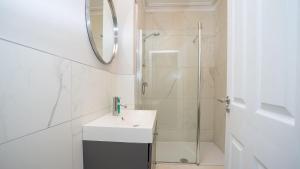 a white bathroom with a sink and a shower at Queens Large 2 BDR & 1 BDR Apartments by Belfast City Breaks in Belfast