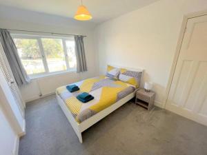 1 dormitorio con cama y ventana en 4-Bedroom House - South London CR7, en Thornton Heath