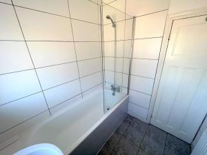 y baño con ducha, bañera y aseo. en 4-Bedroom House - South London CR7, en Thornton Heath