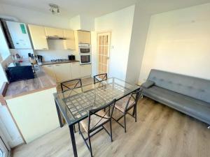 a living room with a glass table and chairs at 4-Bedroom House - South London CR7 in Thornton Heath