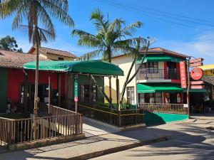 a street scene with a building and palm trees at Pousada e Restaurante Clima da Serra in Cunha