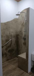 y baño con ducha y pared de hormigón. en Selva Linda Lodge vacation rentals en Quepos