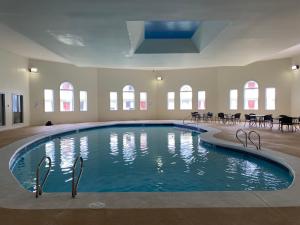 - une grande piscine dans une pièce dotée de tables et de chaises dans l'établissement Whalers Inn and Suites, à New Bedford