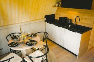 cocina con mesa con sillas y fregadero en Chata Auri / Hütte Auri, en Kaplice