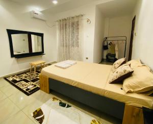 een slaapkamer met een groot bed en een spiegel bij Ngor Rooftop Terrace & Apartment in Dakar