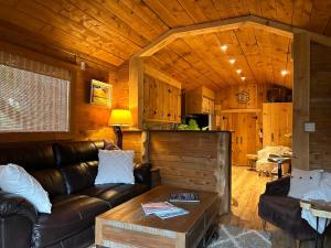 a living room with a leather couch and a table at Cozy Guest House close to Wasaga Beach & Blue Mtn in Nottawa +30 photos
