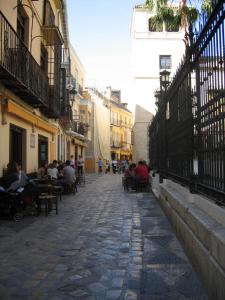 een groep mensen die aan tafels op straat zitten bij Residencia Universitaria San José in Málaga