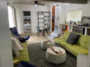 uma sala de estar com sofás verdes e uma cozinha em VILLA GRANDEZZA em Punta Cana