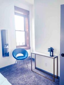 a blue chair sitting in a room with a window at 2Br Unit W/ Cinema Room in Nulu in Louisville +11 photos