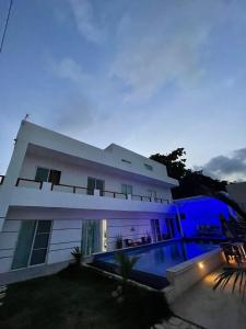 duży biały dom z basenem w nocy w obiekcie VILLA GRANDEZZA w Punta Cana