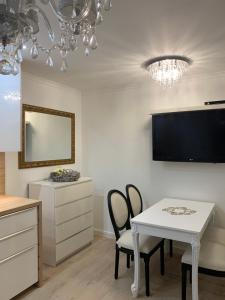 a kitchen with a white table and chairs and a tv at Apartment Naturjuwel in Hünxe