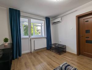 a living room with blue curtains and a door at Cozy Modern Apartment Km 0 Craiova in Craiova