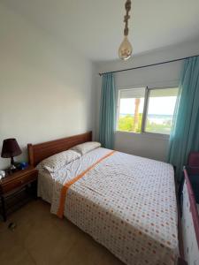 a bedroom with a bed and a window at Bel appartement avec jardin in Fnidek