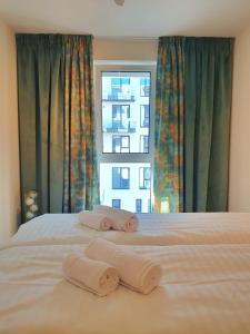 a bedroom with two towels on a bed with a window at Lavish Inn Apartment in Cluj-Napoca