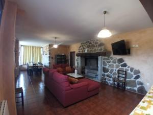 sala de estar con sofá y chimenea en Casa Rural Alada, en Luelmo