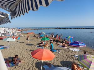 a crowd of people on a beach with umbrellas at Appartamento al mare di Liguria e Toscana in Marina di Massa