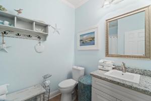 a bathroom with a toilet and a sink and a mirror at Pescador Landing 6A in Pensacola +32 photos