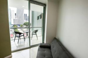 een woonkamer met een bank en een balkon bij Suite Vista al río con Balcón en puerto Santa Ana in Guayaquil