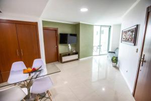 een woonkamer met een tafel en witte stoelen bij Suite Vista al río con Balcón en puerto Santa Ana in Guayaquil