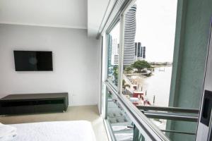 een kamer met een groot raam met uitzicht op het water bij Suite Vista al río con Balcón en puerto Santa Ana in Guayaquil