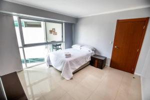 een slaapkamer met een bed en een groot raam bij Suite Vista al río con Balcón en puerto Santa Ana in Guayaquil